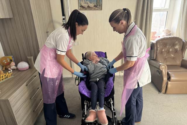 Caoimhe and Samantha help Elizabeth into her bespoke moulded wheelchair