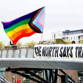 Transgender advocates with a gigantic trans/BLM-inclusive pride flag at the Lagan River footbridge during a demonstration in April
