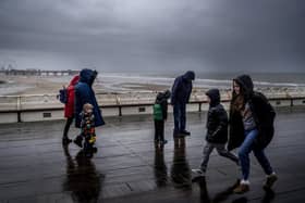 People brave the wind on Blackpool's North Pier amid the approach of Storm Kathleen yesterday.  The forecast for Saturday is strange, of wild winds in Northern Ireland, Scotland and the west coast of England, but also of some of the warmest weather in Britain this year in places (Photo Christopher Furlong/Getty Images)