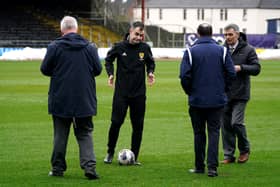 Referee Don Robertson (second left) speaks with Dundee and Rangers officials following a pitch inspection resulting in the cinch Premiership match being called off at Tannadice Park, Dundee.