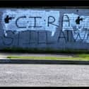 A small child plays in front of CIRA graffiti in Craigavon (picture: PA)