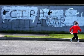 A small child plays in front of CIRA graffiti in Craigavon (picture: PA)