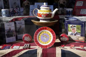 King Charles III and coronation merchandise on display in a shop window near to Windsor Castle.