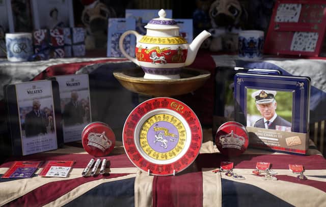 King Charles III and coronation merchandise on display in a shop window near to Windsor Castle.