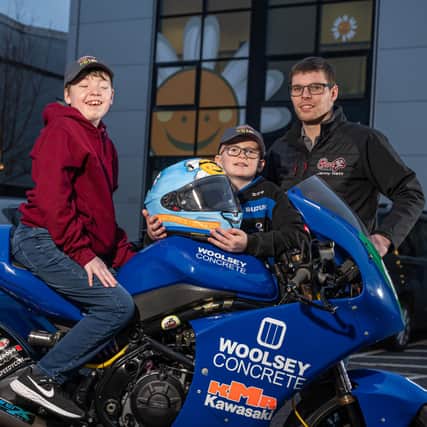 Pictured (l-r) competition winner Aiden MacDougall, and brothers Theo and Jonathan, with the final helmet hand-painted with Aiden’s design.
