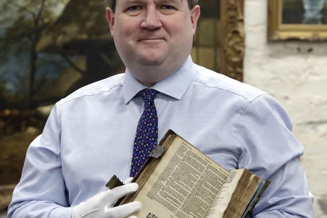 Karl Bennett, Managing Director of Bloomfield Auctions Belfast NI, holding the Geneva Bible