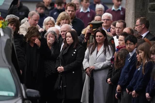 Mourners gather behind the hearse as it leaves St Mary's Church in Ramelton, Co Donegal, after her funeral mass.