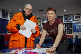 Community worker and activist Jamie Lee Mogey (left) at Carrickfergus Glasgow Rangers Supporters Club, with Lindsay Graham signing a letter calling upon elected representatives to keep their word and remain outside of Stormont until the Irish Sea Border has been removed. Picture: Liam McBurney/PA Wire