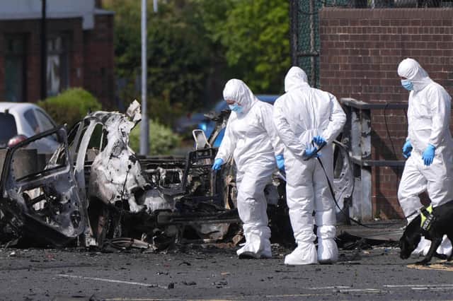 Forensic investigators in Dunmurry after a car bomb detonated outside a police station. Photo: Niall Carson/PA Wire