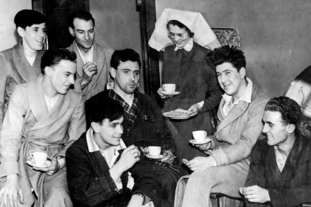 Miss F.L. Currie, Matron of Bangor Hospital, County Down, Northern Ireland, serves morning coffee to seven rescued men now in the hospital after surviving the disaster to the British Transport Commission's car ferry Princess Victoria. The ship foundered in a gale five miles off the County Down coast with the loss of over 130 lives. There were about 170 persons on board.