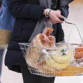 Awoman holding a shopping basket.