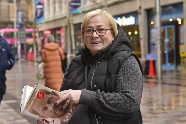 Nuala Lynn in Belfast city centre with Prince Harry's autobiography. Picture by Arthur Allison/Pacemaker Press.