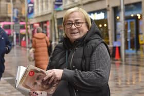 Nuala Lynn in Belfast city centre with Prince Harry's autobiography. Picture by Arthur Allison/Pacemaker Press.