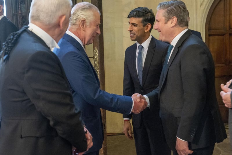King Charles III speaks with Prime Minister Rishi Sunak and Labour leader Sir Keir Starmer  during his visit to Westminster Hall at the Palace of Westminster to attend a reception ahead of the coronation.