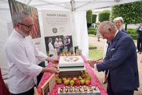 King Charles III cuts a cake to celebrate four decades of the Prince of Wales's Charitable Fund, with Waitrose senior chef Will Torrent (left) during a reception at Clarence House, London
