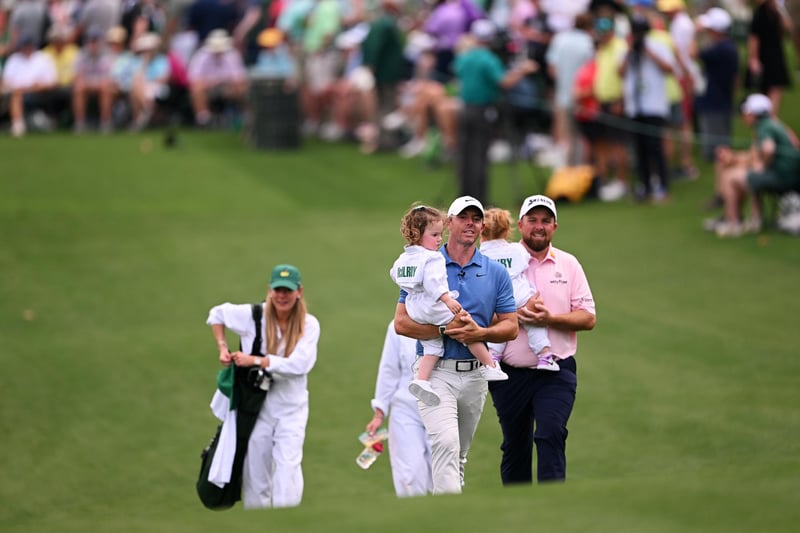 AUGUSTA, GEORGIA - APRIL 05: Rory McIlroy of Northern Ireland  walks up the first fairway with his daughter Poppy McIlroy during the Par 3 contest prior to the 2023 Masters Tournament at Augusta National Golf Club on April 05, 2023 in Augusta, Georgia. (Photo by Ross Kinnaird/Getty Images)