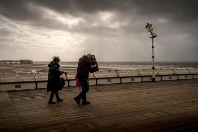The west coast of England was also battered. In this picture, people brave the wind and rain on Blackpool's North Pier on Friday as heavy clouds coming from the west mark the approach of Storm Kathleen (Photo by Christopher Furlong/Getty Images)