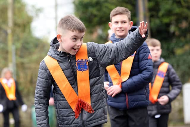PACEMAKER, BELFAST, 2/4/2024: A young member of Ballycastle District Junior LOL No.8 waves to a well wisher during the Junior Orange parade in Ballymoney, Co. Antrim today.PICTURE BY STEPHEN DAVISON