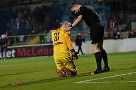 Glentoran’s Aaron McCarey goes down injured after appearing to be struck by a missile during the 'Big Two' derby