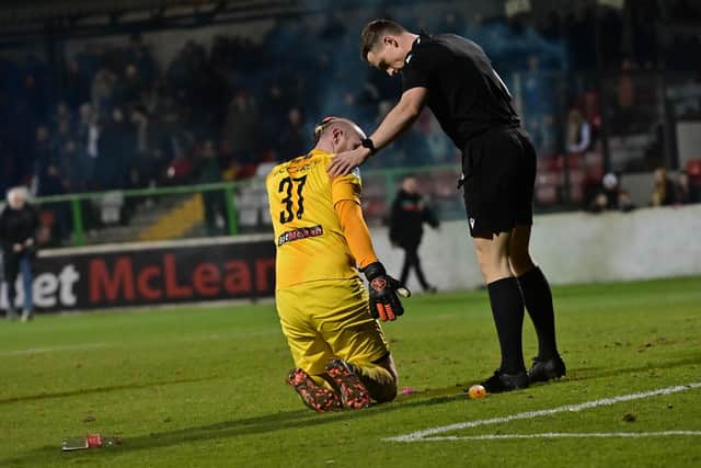 Glentoran’s Aaron McCarey goes down injured after appearing to be struck by a missile during the 'Big Two' derby