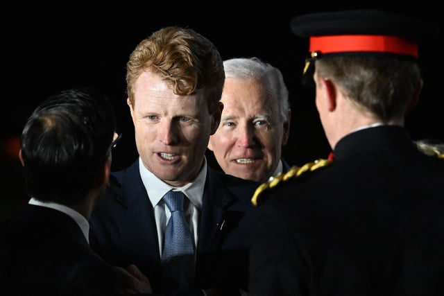 US President Joe Biden (2R) reacts as Britain's Prime Minster Rishi Sunak (L) greets with United States Special Envoy for Northern Joe Kennedy (2L), after they disembarked from Air Force One upon arrival at Belfast International Airport on April 11, 2023, starting a four day trip to Northern Ireland and Ireland to launch 25th anniversary commemorations of the "Good Friday Agreement" deal that brought peace to Northern Ireland. - US President Joe Biden arrived in Northern Ireland on Tuesday, hoping to help maintain the fragile peace brokered 25 years ago after decades of sectarian violence over British rule. (Photo by Jim WATSON / AFP) (Photo by JIM WATSON/AFP via Getty Images)
