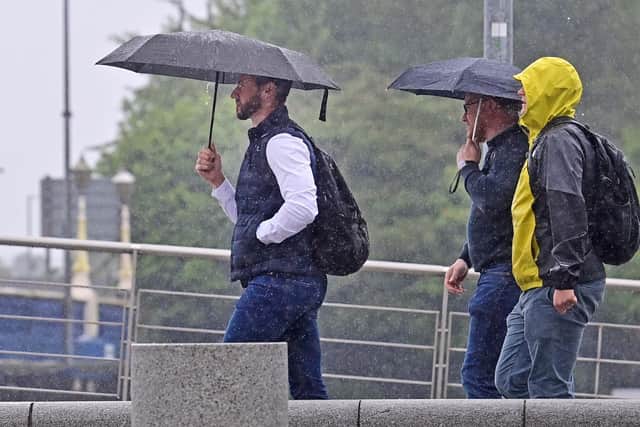 Sheltering from the rain during a wet day in Belfast city centre today (Tuesday). Pic Colm Lenaghan/ Pacemaker