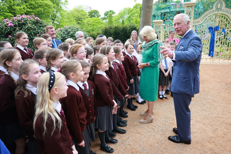 King Charles III and Queen Camilla greet school children during a visit to open the new Coronation Garden on day one of their two-day visit to Northern Ireland on May 24, 2023 in Newtownabbey, Northern Ireland. King Charles III and Queen Camilla are visiting Northern Ireland for the first time since their Coronation. Their Majesties will met designers of the Garden and representatives of community and charitable organisations, hearing how the Garden marks the beginning of a new green initiative for the Antrim and Newtownabbey Borough Council. (Photo by Chris Jackson/Getty Images)