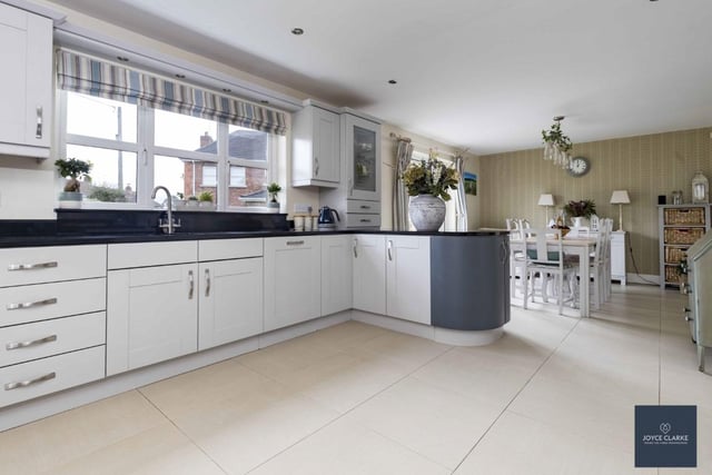 The stylish fitted kitchen has a range of high and low level units, display cabinets and breakfast bar with granite work surfaces and an array of integrated appliances.