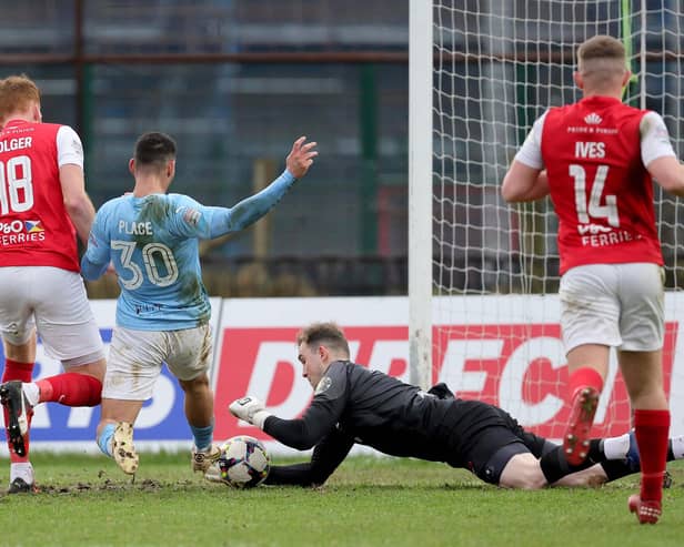 Larne's Rohan Ferguson saves at the feet of Ballymena's Mikey Place during the Premiership clash at The Showgrounds
