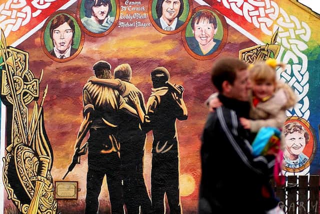 A man and his child pass by an IRA mural, 2005