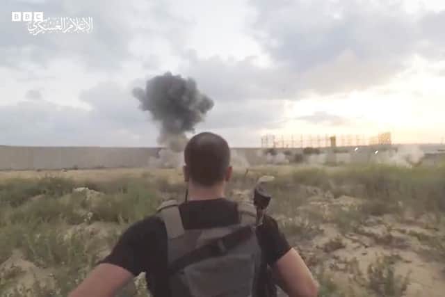 A Hamas gunman running towards the Israeli border on Saturday, as shown on a Hamas propaganda channel (and subsequently publicised by the BBC - dark, low-resolution image has had brightness boosted)