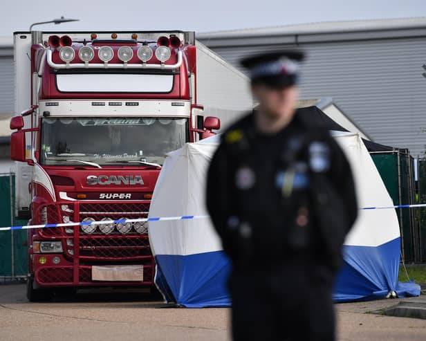 A police officer secures the cordon at at the scene where a lorry was found containing 39 dead bodies