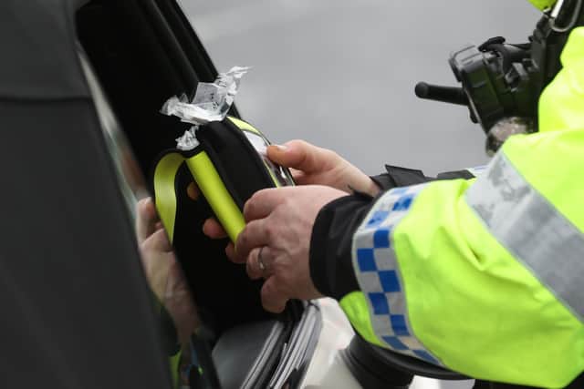 A police officer looking at a breathalyser at the launch of the 2022/23 police winter anti-drink/drug drive operation on Sydenham Road in Belfast. Picture date: Thursday December 1, 2022.