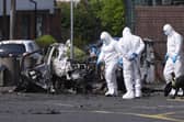 Forensic investigators at the scene in Dunmurry after a car explosion outside a police station