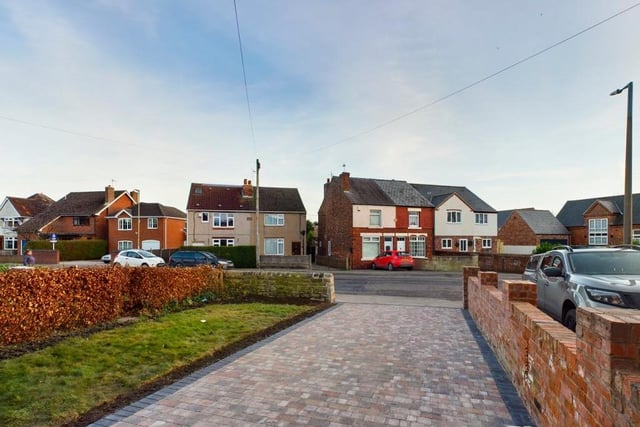 At the front of the £250,000 property, this spacious driveway provides plenty of space for off-street parking. Either side of the drive are a lawned garden with a hedged border, and a dry stone boundary wall.