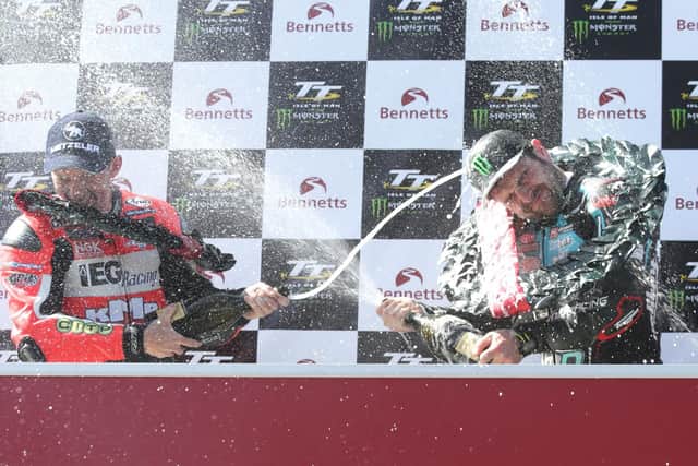 Lightweight TT runner-up Derek McGee celebrates on the podium with Michael Dunlop last year.