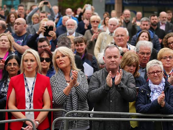 The public outside St. Anne's Cathedral, Belfast, applaud Lyra McKee as her coffin is carried inside.