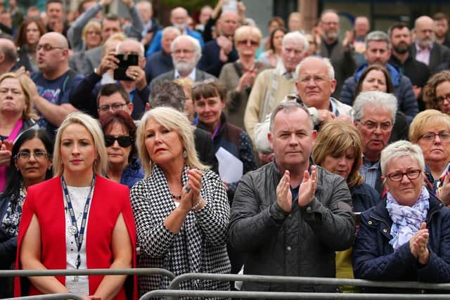 The public outside St. Anne's Cathedral, Belfast, applaud Lyra McKee as her coffin is carried inside.