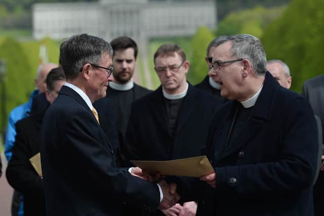 Presbyterian Moderator Gordon Dane hands a letter of protest to David Seaton (chairman of the Belfast Marathon) during a protest rally at Stormont.