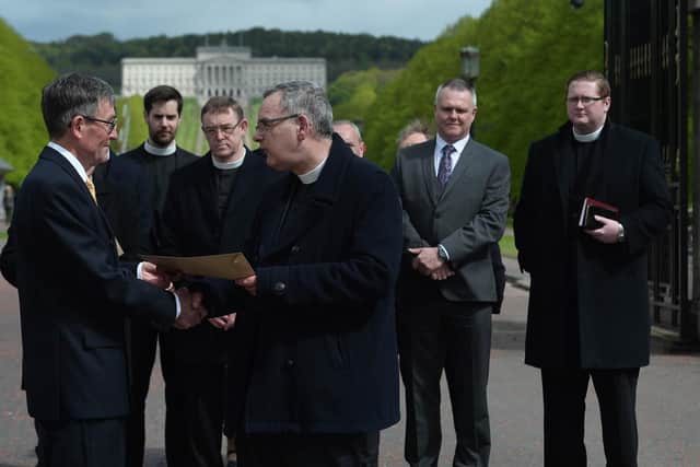 Presbyterian Moderator Gordon Dane hands a letter of protest to David Seaton (chairman of the Belfast Marathon) during a protest rally at Stormont.