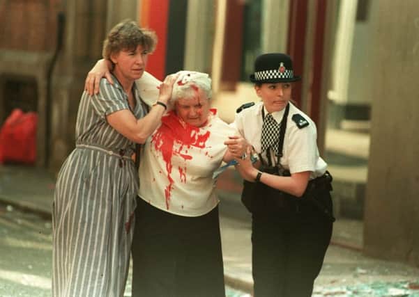 PC Vanessa Winstanley and another woman help an elderly injured woman after the IRA bomb in Manchester city centre in 1996. Pic: Press Association.