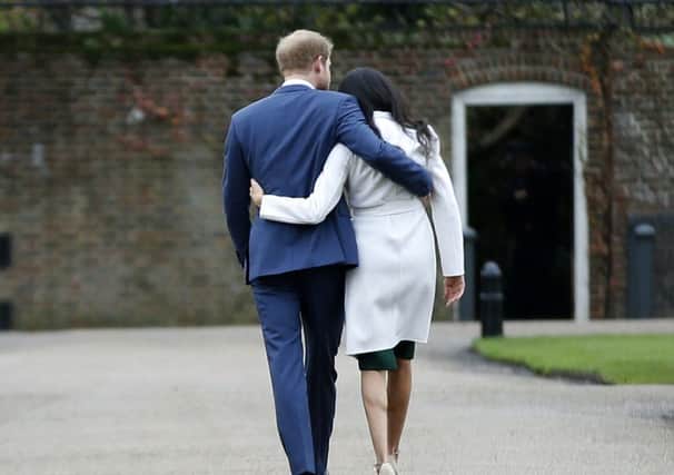 Britain's Prince Harry and Meghan Markle walk away after posing for the media in the grounds of Kensington Palace in London, Monday Nov. 27, 2017