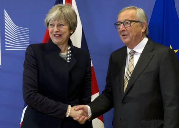 European Commission President Jean-Claude Juncker, right, greets UK Prime Minister Theresa May prior to a meeting at EU headquarters in Brussels on Monday. (AP Photo/Virginia Mayo)