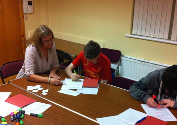 Suzanne Campbell-Hanna pictured helping students at the 'reading between the lines' project in Londonderry