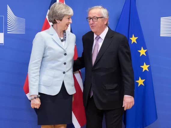 EU President Jean-Claude Juncker standing with British Prime Minister Theresa May at the EU Commission in Brussels.
