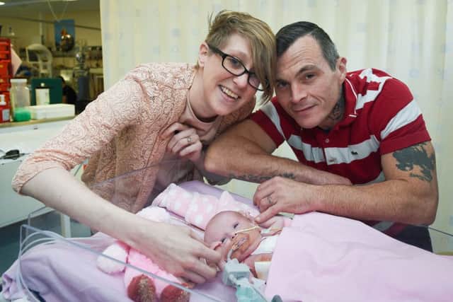 EMBARGOED TO 2230 TUESDAY DECEMBER 12 

Three-week-old Vanellope Hope Wilkins, who was due to be delivered on Christmas Eve before an incredibly rare condition, in which the heart grows on the outside of the body, meant she had to be born prematurely by caesarean section on November 22, is caressed and touched by her parents Naomi Findlay and Dean Wilkins, at Glenfield Hospital in Leicester, after surviving, in what is believed to be a UK first. PRESS ASSOCIATION Photo. Picture date: Monday December, 11, 2017. The condition, Ectopia cordis, which was discovered during a scan after nine weeks' pregnancy, showed the baby's heart and part of her stomach were growing on the outside of her body.
The parents, Naomi Findlay and Dean Wilkins, of Bulwell, Nottinghamshire, said the first scans led doctors to tell them that "termination" was the only option. And experts, including the consultant cardiologist, have said that they do not know of a case in the UK where a baby has survived such a condition. See PA story HEA