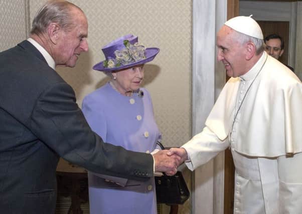 The Duke of Edinburgh shakes hands with Pope Francis while the Queen looks on, during a visit to the Vatican in 2014
