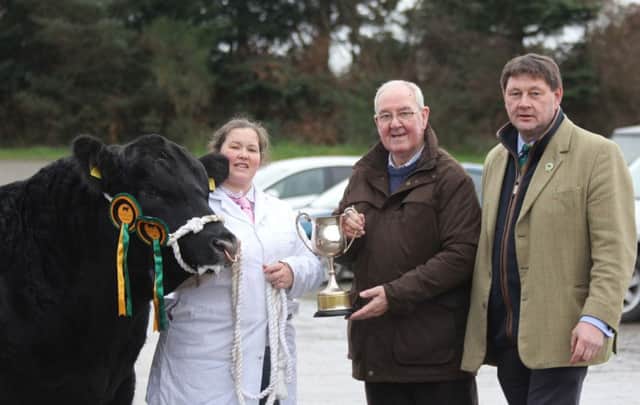 Male champion at the Aberdeen Angus Cattle Society's Dungannon show and sale was Tullybryan Black Brexit S906 bred by Fiona Troughton, Ballygawley. Presenting the trophy are judge Desmond Mackey, Lisburn; and society president Alex Sanger. Picture: Julie Hazelton