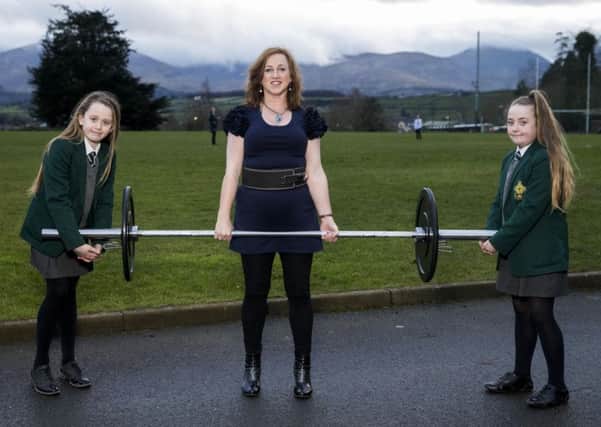 Powerlifting medal winner Lucille Rowan, 50, who teaches mathematics at St Malachy's High School in rural Co Down, with her pupils Cailtlin Boyle (left) and Leah Mills. Photo: Liam McBurney/PA Wire