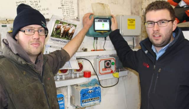 Fintona milk producer Raymond Caldwell and NMR's John Graham viewing the SCR Heatime controller, which is located on the wall of the Caldwell's dairy